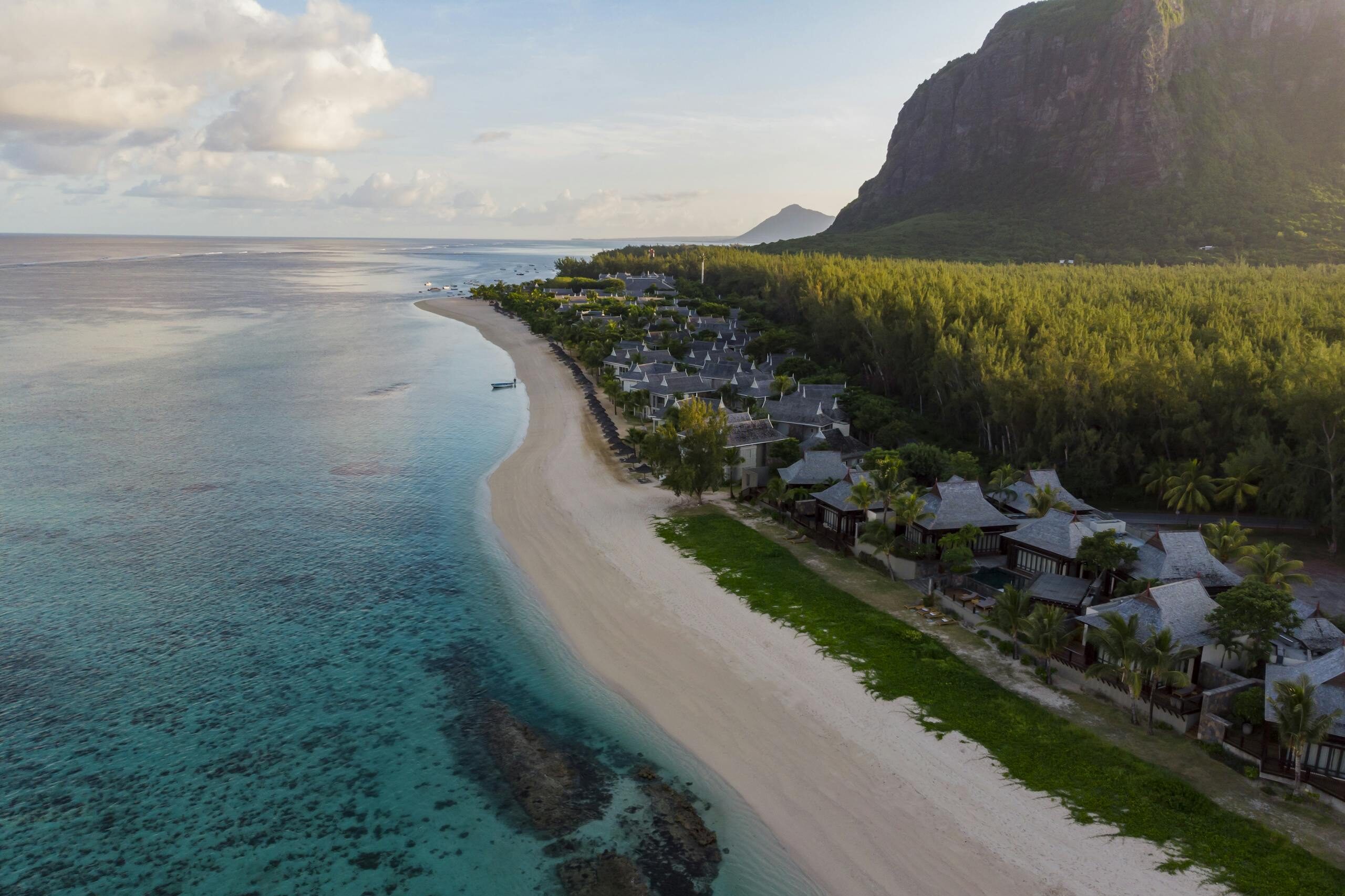 Aerial photograph of a tranquil beach resort in Mauritius with clear waters and lush greenery.