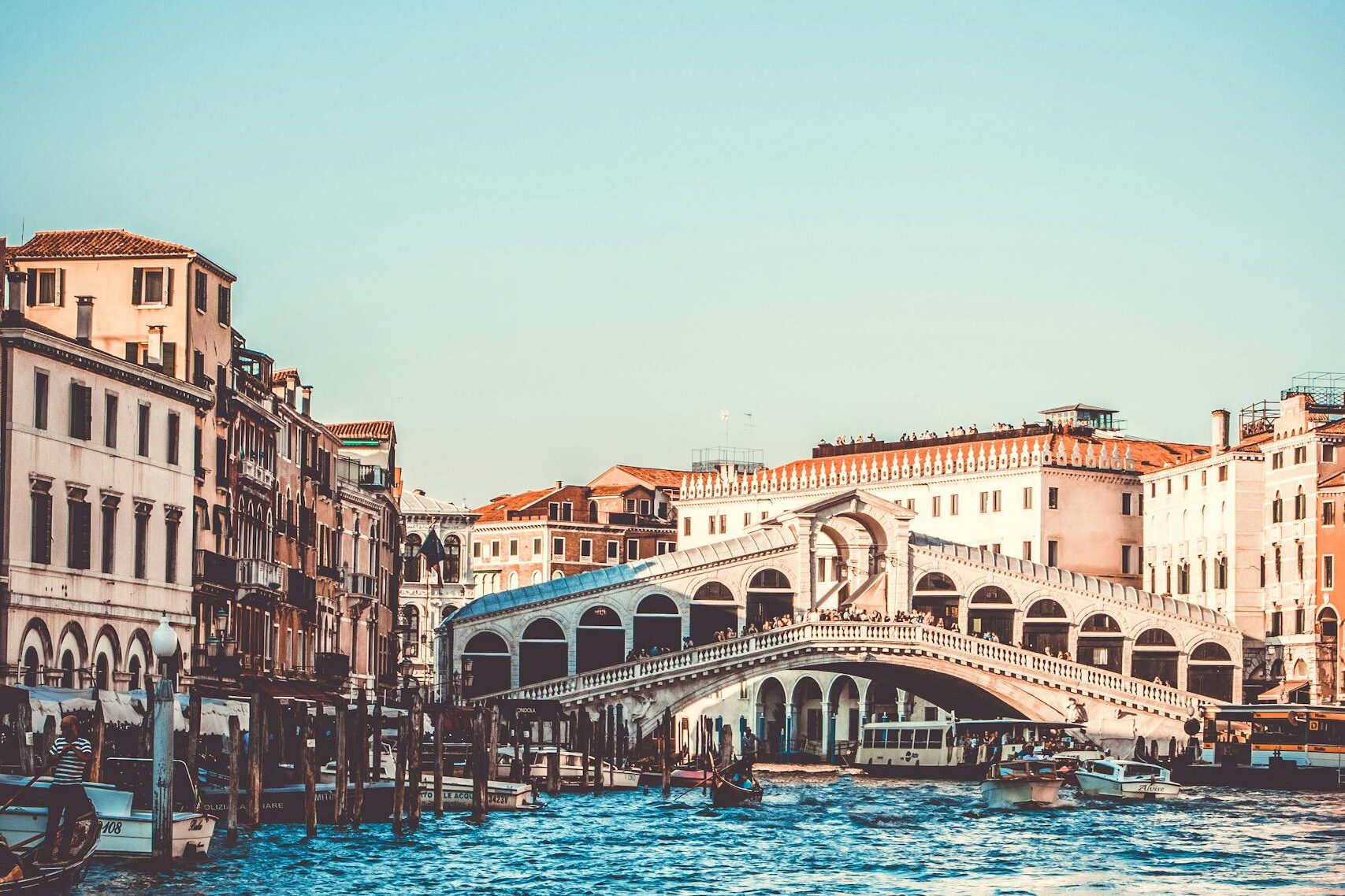 Explore the iconic Rialto Bridge over the Grand Canal in Venice, a must-visit tourist spot.
